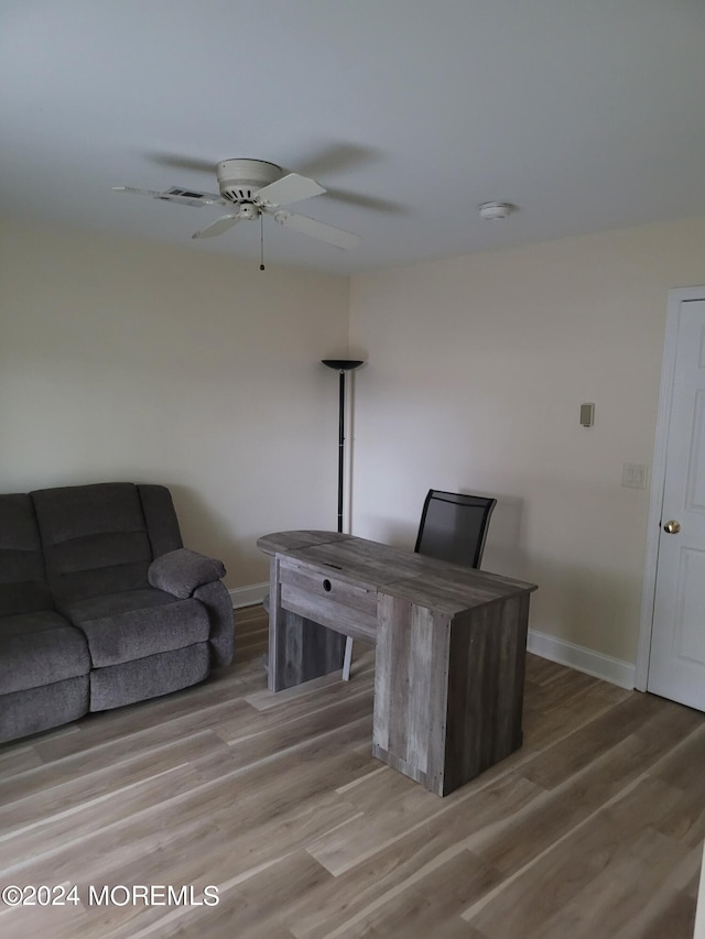 office featuring light wood-style floors, ceiling fan, and baseboards