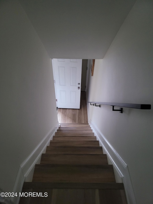 stairway featuring baseboards and wood finished floors