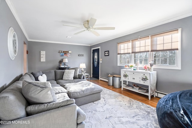 living room with a baseboard radiator, ceiling fan, wood finished floors, baseboard heating, and crown molding