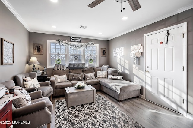 living area with visible vents, ceiling fan, ornamental molding, wood finished floors, and recessed lighting