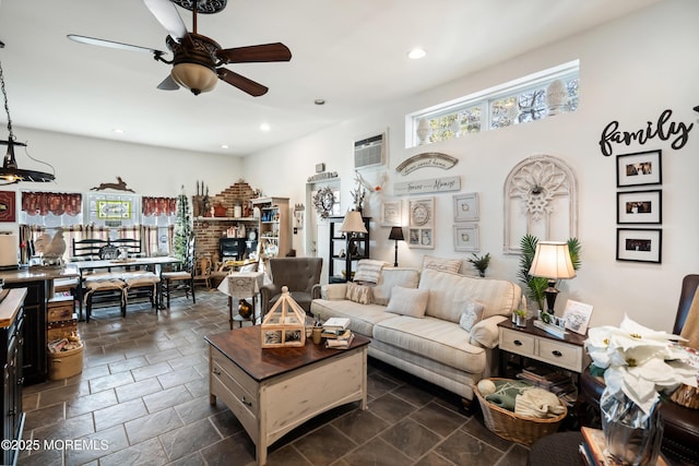 living area featuring recessed lighting, a fireplace, a ceiling fan, and stone tile floors