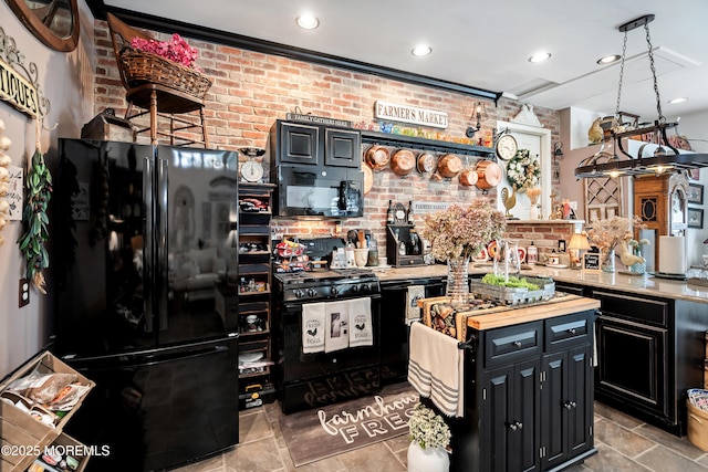 kitchen with brick wall, a kitchen island, light countertops, dark cabinetry, and black appliances