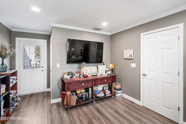 entrance foyer featuring ornamental molding, visible vents, baseboards, and wood finished floors