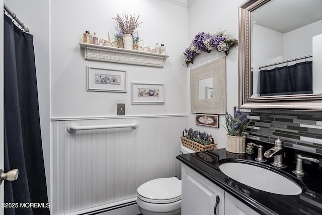 full bath with a baseboard radiator, a wainscoted wall, vanity, and toilet