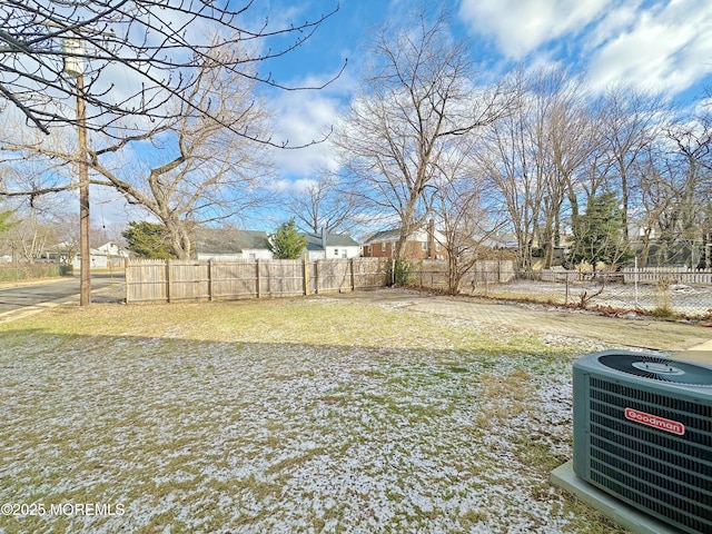 view of yard featuring fence and central AC unit