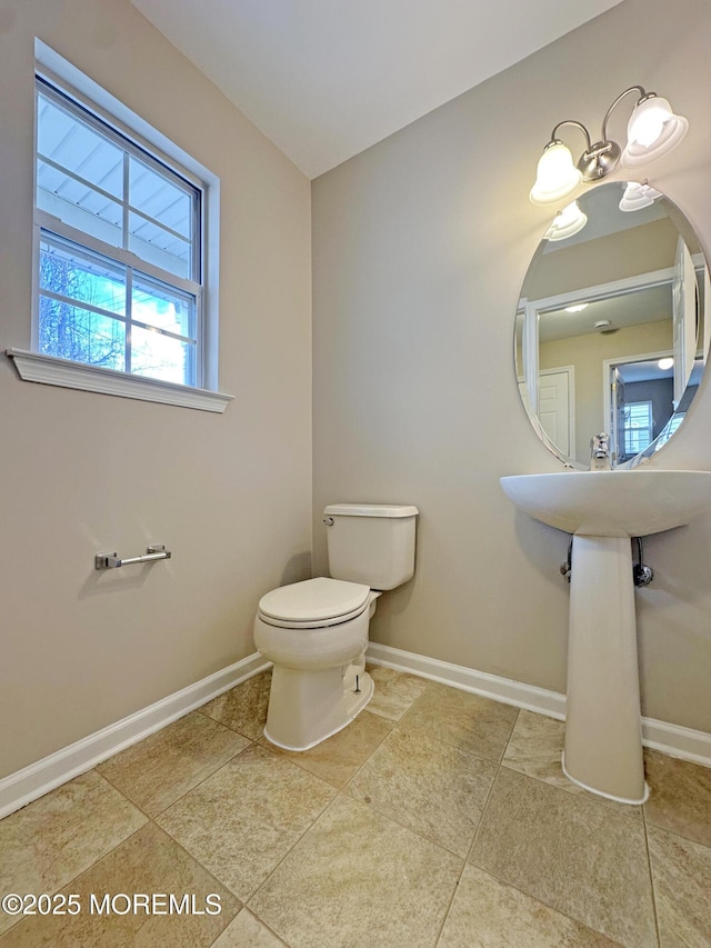 bathroom featuring toilet and baseboards