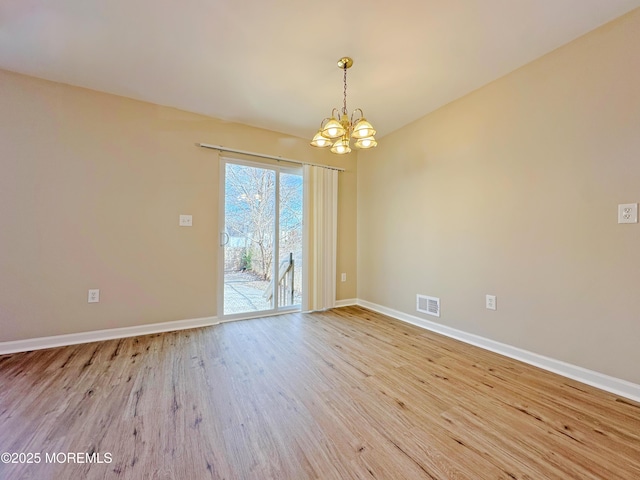 unfurnished room with a chandelier, light wood-type flooring, visible vents, and baseboards