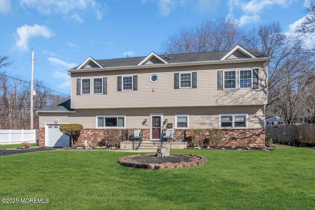 view of front facade featuring a front lawn, aphalt driveway, fence, a garage, and brick siding