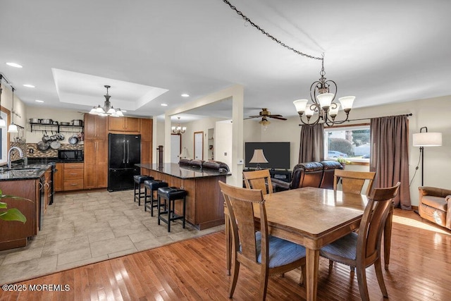551 Chester Pkwy, Belford, NJ 07718 - dining area featuring recessed lighting, a tray ceiling, ceiling fan with notable chandelier, and light wood finished floors