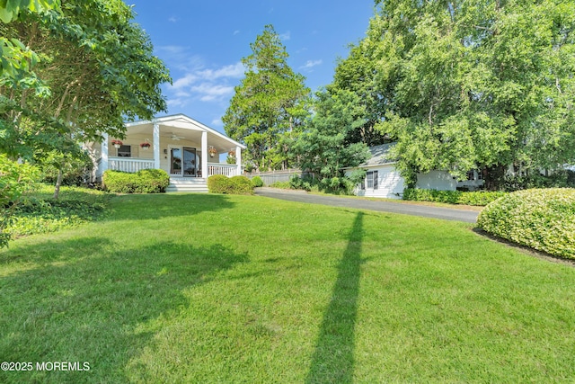 view of yard featuring covered porch and ceiling fan