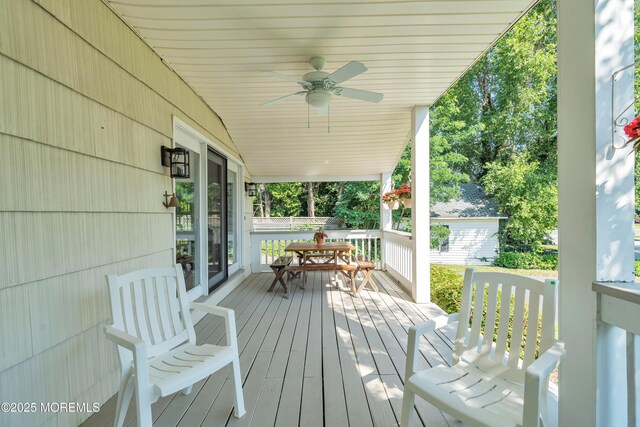 wooden deck featuring a ceiling fan and outdoor dining space