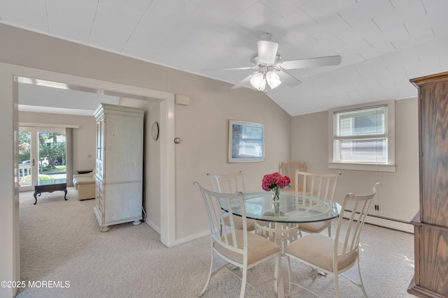 dining space with a baseboard radiator, light carpet, vaulted ceiling, ceiling fan, and baseboards