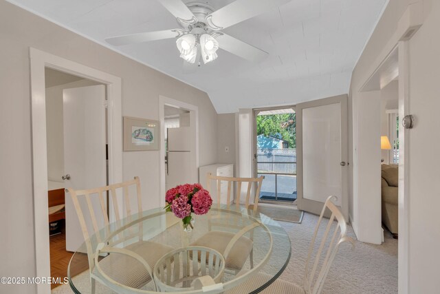 dining space with a ceiling fan and vaulted ceiling