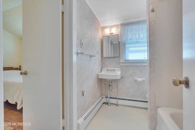 ensuite bathroom with a sink, a bathtub, a baseboard heating unit, and connected bathroom