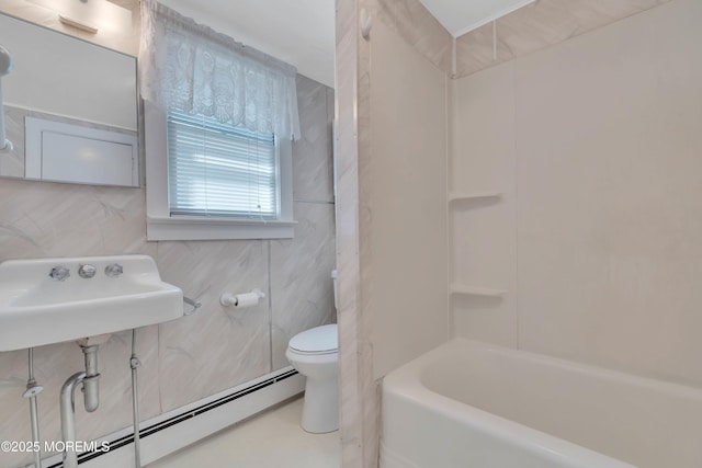 bathroom featuring baseboard heating, a sink, toilet, and tile walls