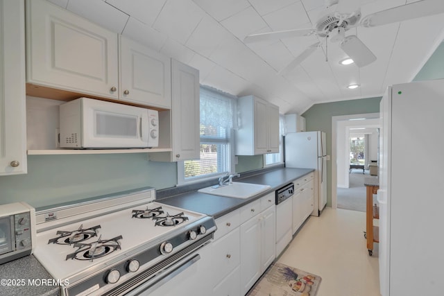 kitchen with a wealth of natural light, white appliances, a sink, and white cabinetry