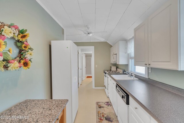 kitchen with a ceiling fan, white cabinetry, vaulted ceiling, a sink, and white appliances