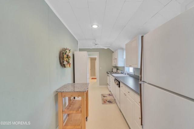 kitchen featuring white appliances, a ceiling fan, lofted ceiling, white cabinetry, and a sink