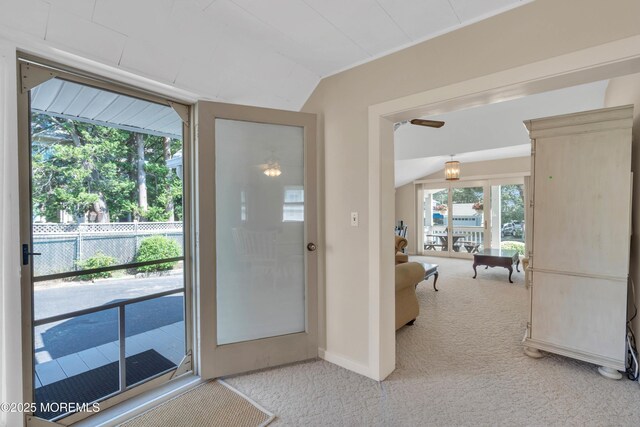 doorway with light carpet and lofted ceiling