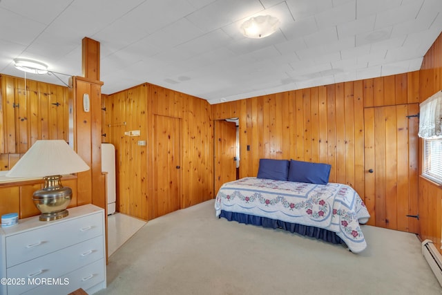 carpeted bedroom with a baseboard radiator and wooden walls