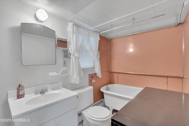 bathroom with toilet, a freestanding tub, and vanity