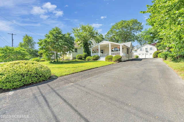 view of front of property with a garage, a front lawn, and a porch