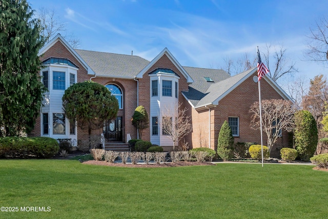 traditional-style home featuring brick siding and a front lawn