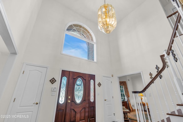 foyer entrance featuring an inviting chandelier, stairway, and a high ceiling