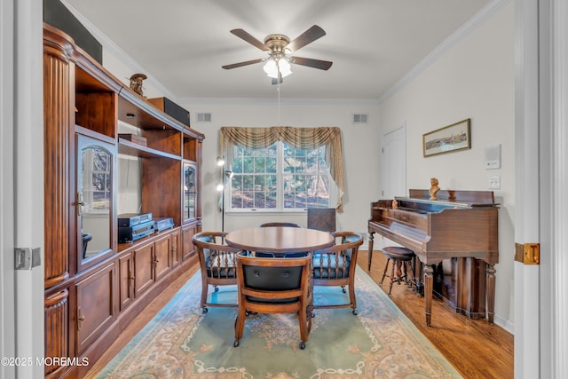 dining area with visible vents, ornamental molding, and wood finished floors