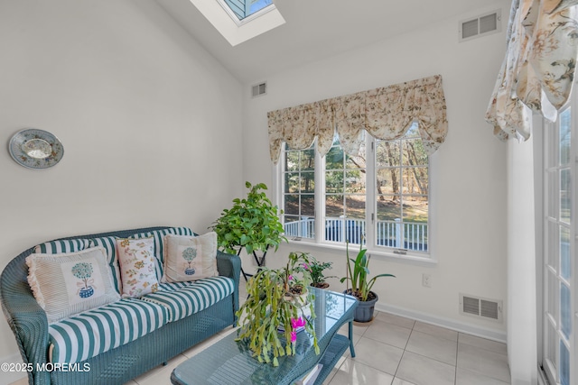 living room with tile patterned flooring, visible vents, a skylight, and baseboards