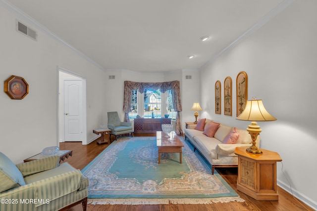 living room featuring crown molding, wood finished floors, visible vents, and baseboards