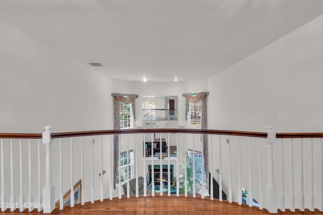 hall featuring an upstairs landing and visible vents