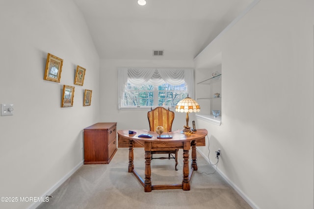 office area featuring light carpet, visible vents, lofted ceiling, and baseboards