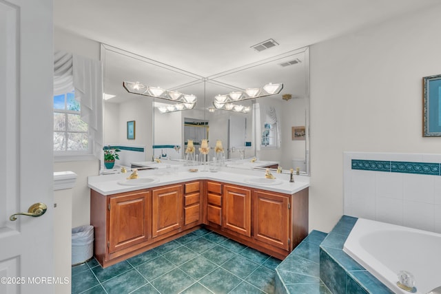 full bath with tile patterned floors, visible vents, a sink, double vanity, and a bath