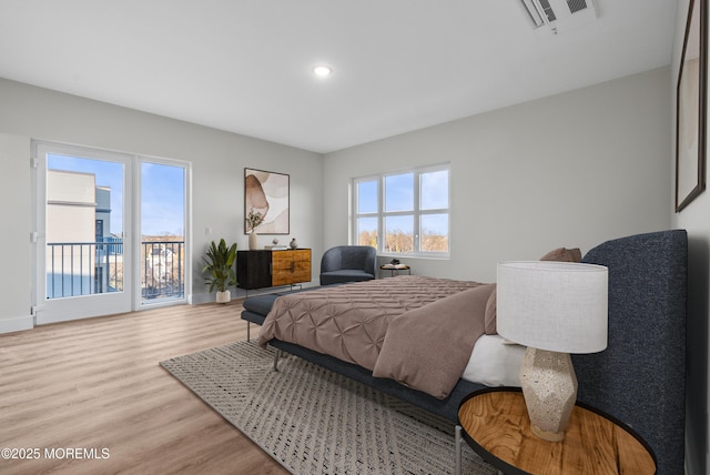 bedroom featuring light wood-type flooring, visible vents, and multiple windows