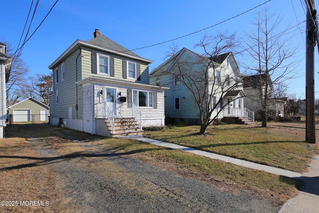 197 Church St, Belford, NJ 07718 - view of front facade with a garage, an outdoor structure, a front yard, a chimney, and driveway