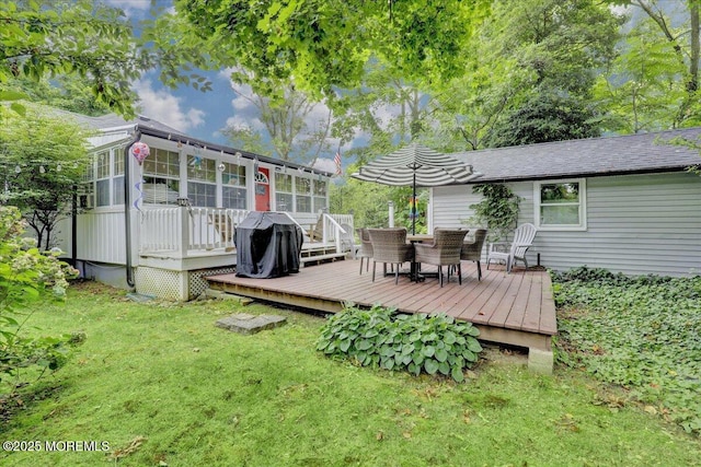 wooden terrace with outdoor dining space, a sunroom, and a lawn