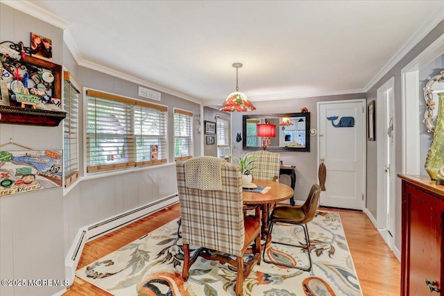 dining space featuring light wood finished floors, a baseboard radiator, and crown molding