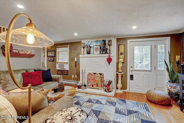 living area featuring a baseboard radiator, crown molding, recessed lighting, and wood finished floors