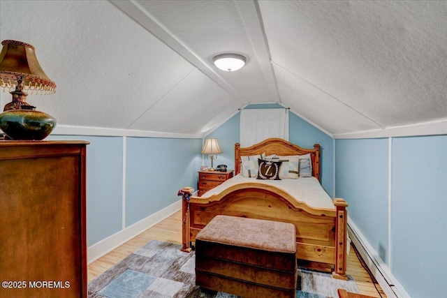 bedroom with lofted ceiling, a textured ceiling, a baseboard heating unit, and wood finished floors