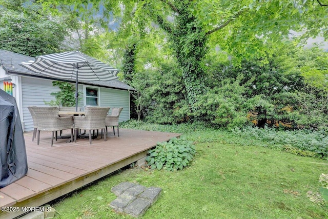 view of yard featuring outdoor dining area and a wooden deck