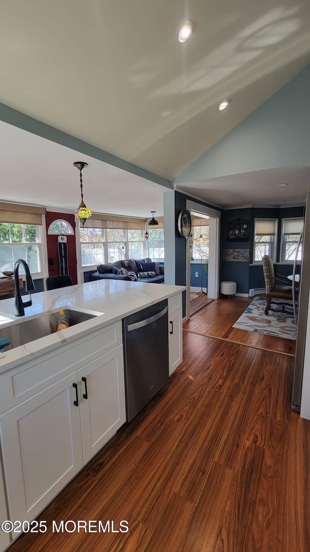 kitchen featuring dark wood-style flooring, vaulted ceiling, stainless steel appliances, white cabinetry, and a sink