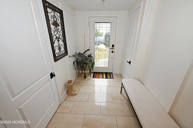 foyer entrance featuring light tile patterned flooring and baseboards