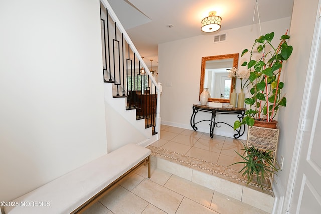 entryway with baseboards, stairway, visible vents, and tile patterned floors