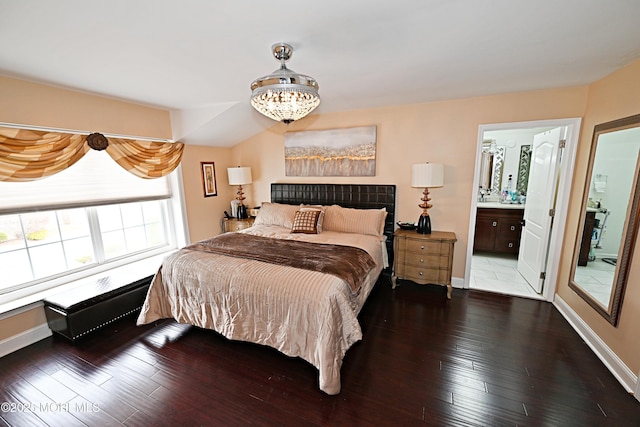 bedroom with hardwood / wood-style flooring, baseboards, and an inviting chandelier