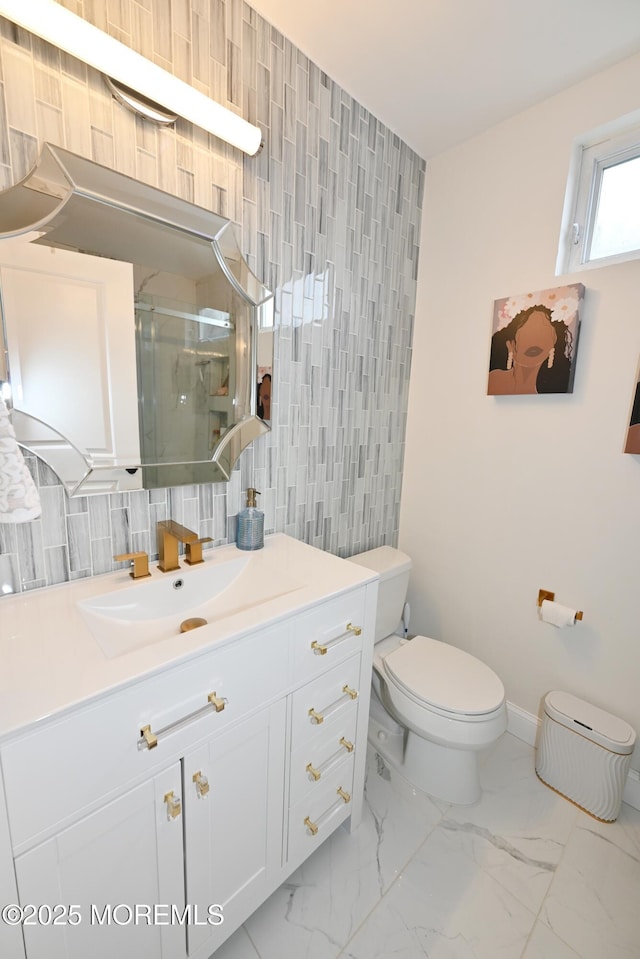 full bathroom with marble finish floor, tile walls, toilet, a shower stall, and vanity