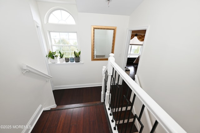 stairway with vaulted ceiling, hardwood / wood-style floors, and baseboards