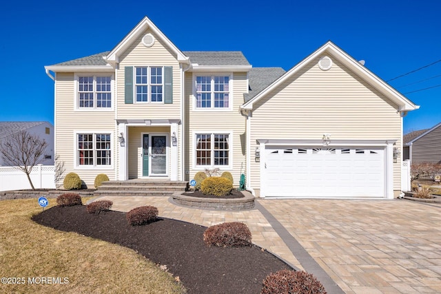 view of front of home with a garage and decorative driveway