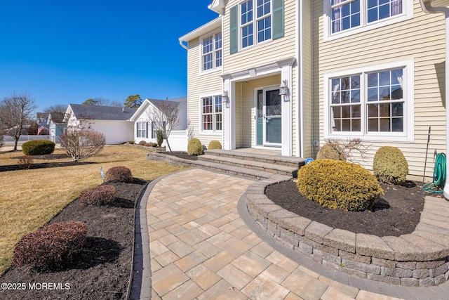 view of exterior entry featuring a yard