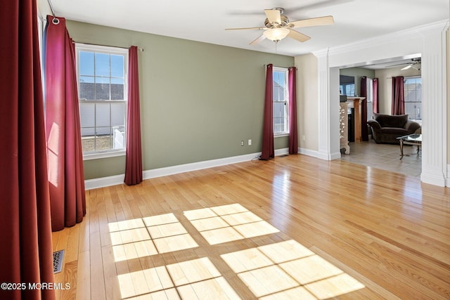 unfurnished room featuring light wood-style floors, a fireplace, baseboards, and ceiling fan